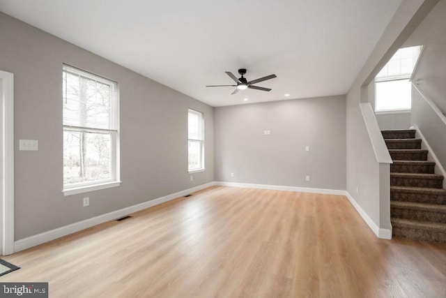 unfurnished living room with plenty of natural light, ceiling fan, and light hardwood / wood-style floors