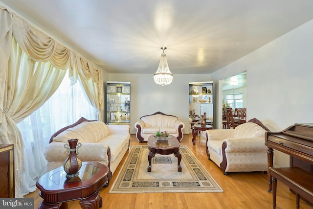 living room featuring light hardwood / wood-style flooring, a wealth of natural light, and a notable chandelier