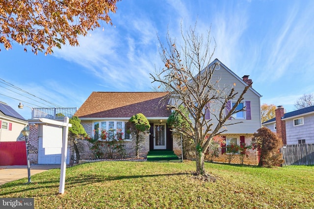 view of front of home with a balcony and a front lawn