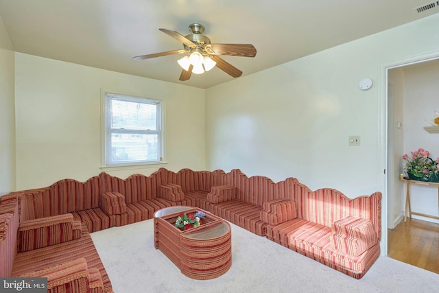 living room featuring wood-type flooring and ceiling fan