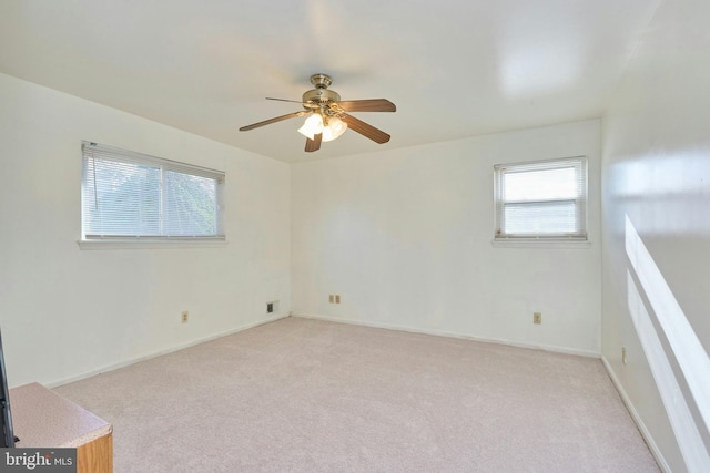 empty room featuring ceiling fan and light colored carpet