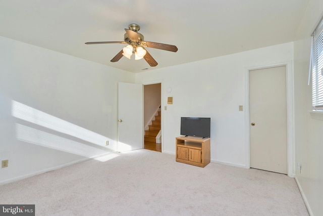 unfurnished living room featuring ceiling fan and light colored carpet