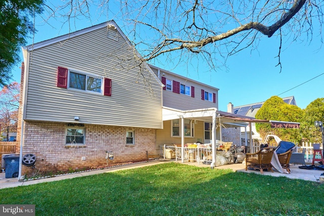 rear view of property with a lawn and a patio