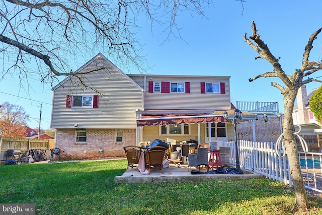 back of house featuring a yard, a balcony, and a patio