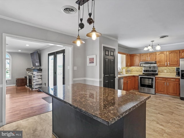 kitchen with pendant lighting, plenty of natural light, light hardwood / wood-style floors, and appliances with stainless steel finishes