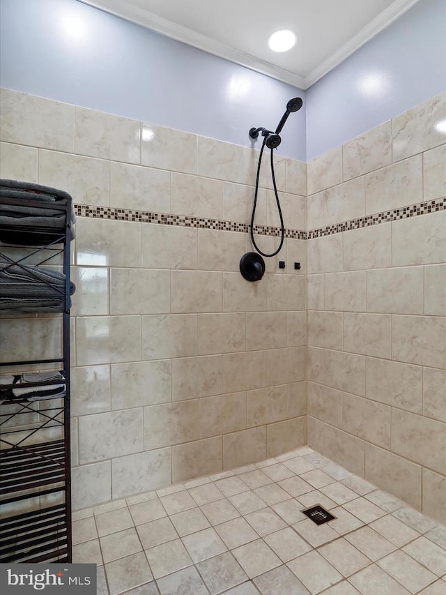 bathroom with tile patterned flooring, tiled shower, and crown molding