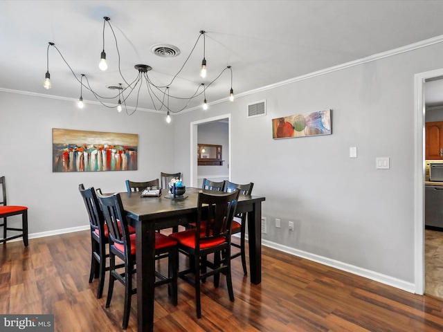 dining room with dark hardwood / wood-style flooring, a notable chandelier, and ornamental molding