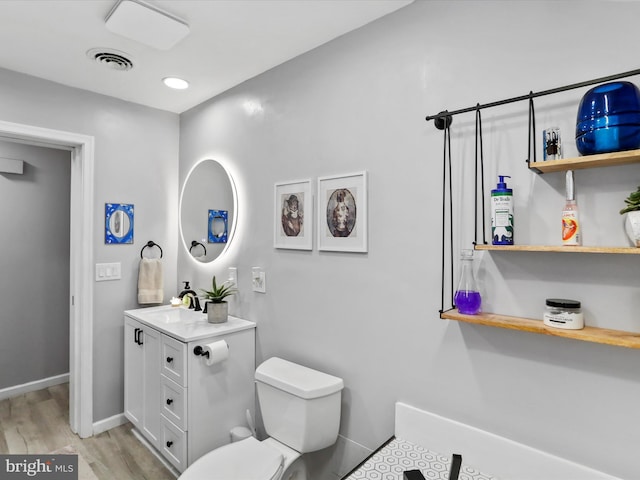 bathroom with hardwood / wood-style flooring, vanity, and toilet