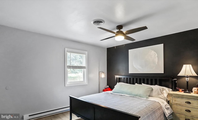 bedroom with light hardwood / wood-style floors, baseboard heating, and ceiling fan