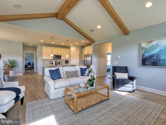 living room with light hardwood / wood-style floors and lofted ceiling with beams