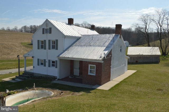 909 Ridge Rd, Westminster, MD 21157 - back of property with a chimney, metal roof, a lawn, a porch, and brick siding