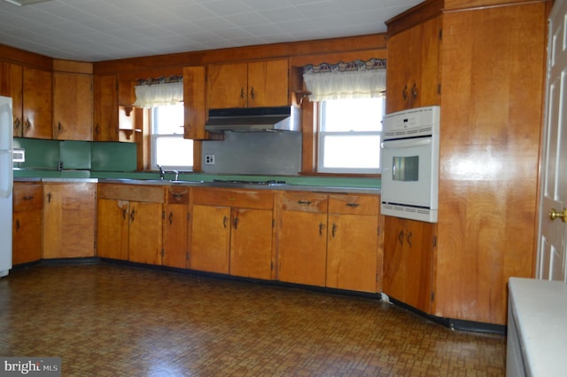 909 Ridge Rd, Westminster, MD 21157 - kitchen featuring brown cabinets, cooktop, under cabinet range hood, and oven