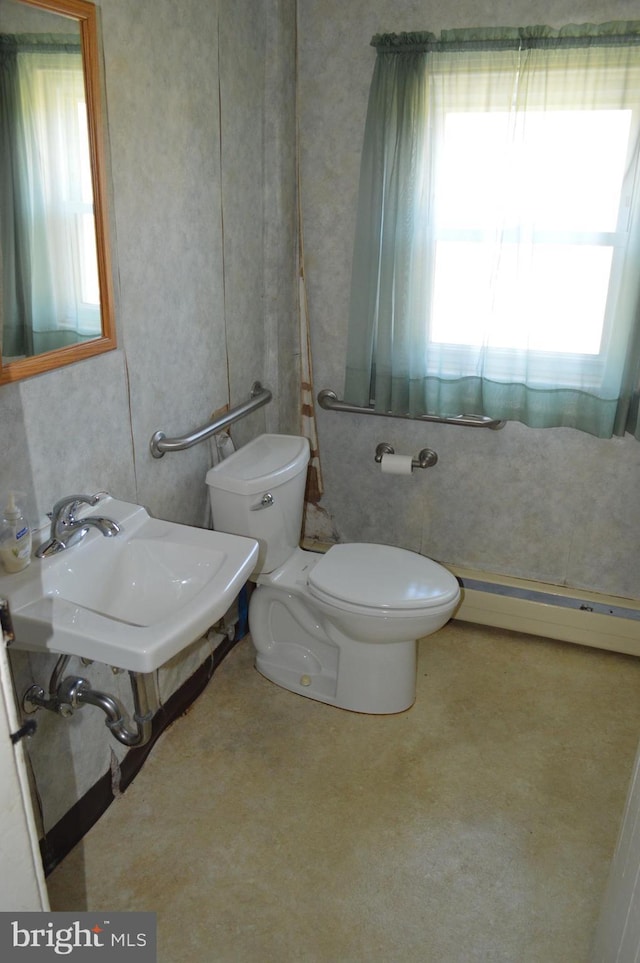 909 Ridge Rd, Westminster, MD 21157 - half bath with a baseboard heating unit, toilet, a sink, and a healthy amount of sunlight