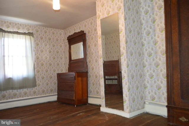 909 Ridge Rd, Westminster, MD 21157 - unfurnished bedroom featuring dark wood finished floors, wallpapered walls, a baseboard heating unit, and a baseboard radiator
