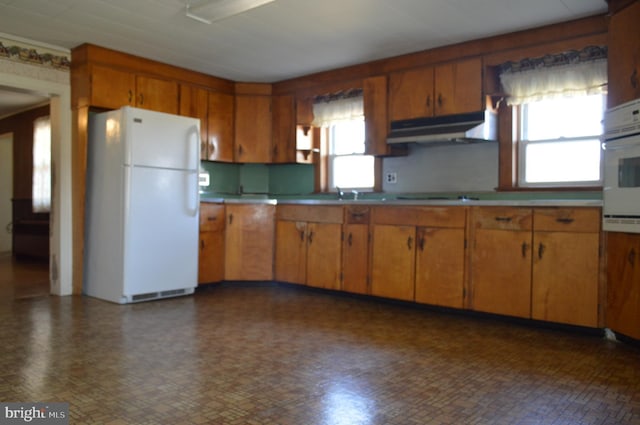 909 Ridge Rd, Westminster, MD 21157 - kitchen featuring brown cabinetry, plenty of natural light, under cabinet range hood, and white appliances