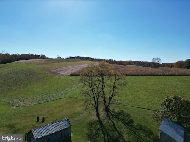 exterior space featuring a rural view and a lawn