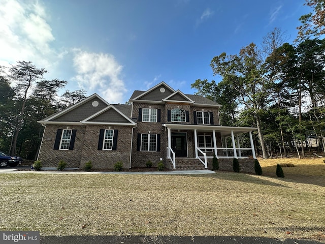 view of front of home featuring covered porch and a front yard