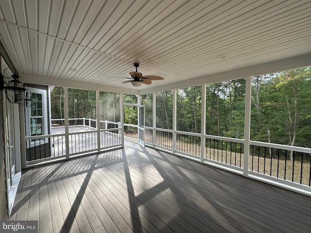 unfurnished sunroom featuring ceiling fan and plenty of natural light