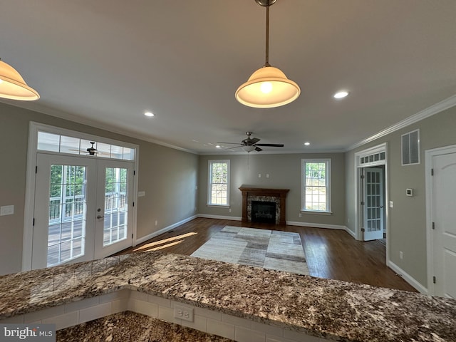 unfurnished living room featuring dark hardwood / wood-style flooring, crown molding, french doors, and ceiling fan