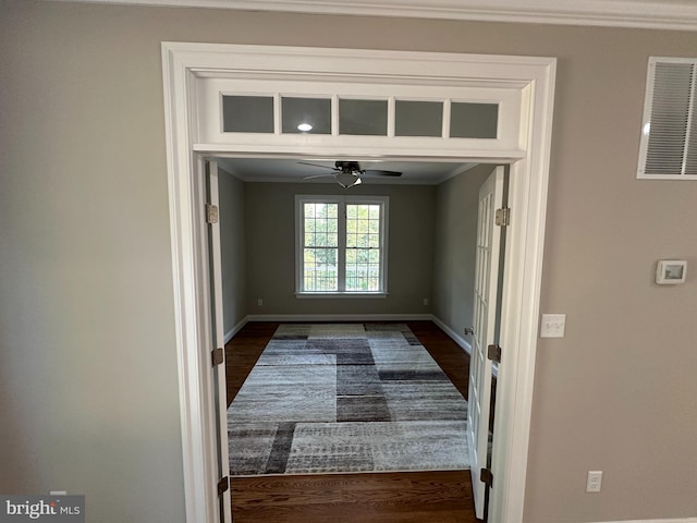 doorway to outside featuring ornamental molding, dark wood-type flooring, and ceiling fan