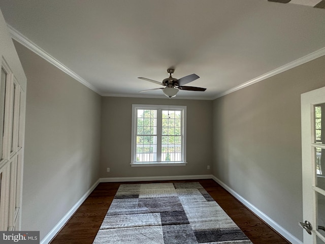 empty room featuring dark wood-type flooring, ceiling fan, and crown molding