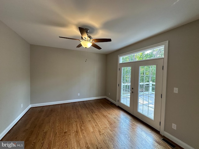 empty room with french doors, hardwood / wood-style flooring, and ceiling fan