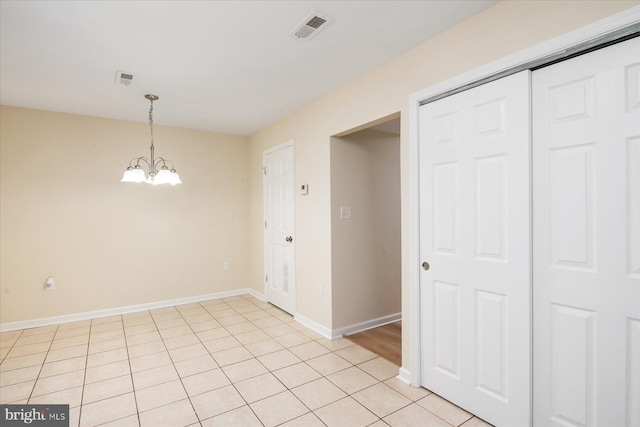 unfurnished dining area featuring light tile patterned flooring and a chandelier