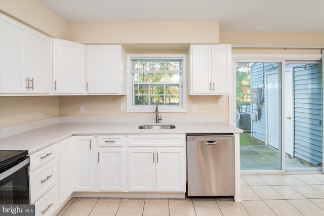 kitchen featuring light tile patterned flooring, sink, electric range oven, stainless steel dishwasher, and white cabinets