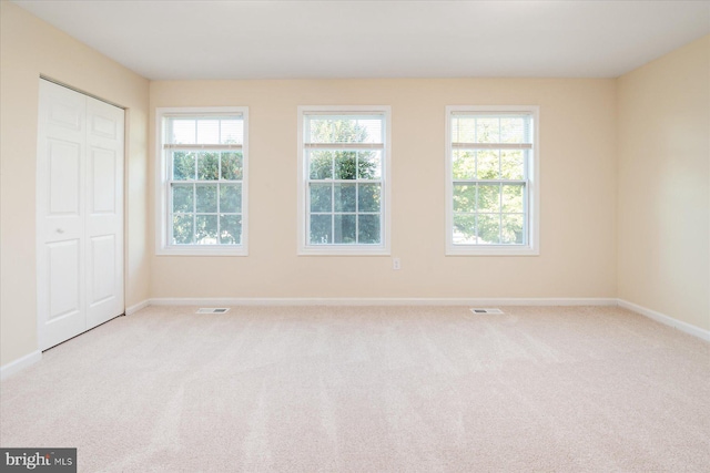 empty room with light carpet and plenty of natural light