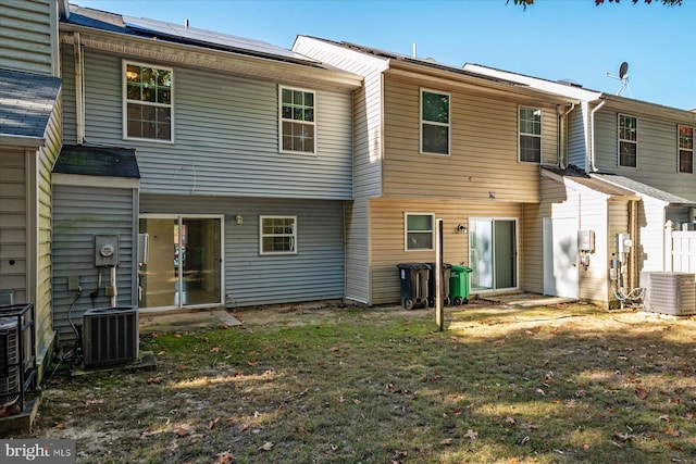 rear view of property with central air condition unit, a patio area, and a yard