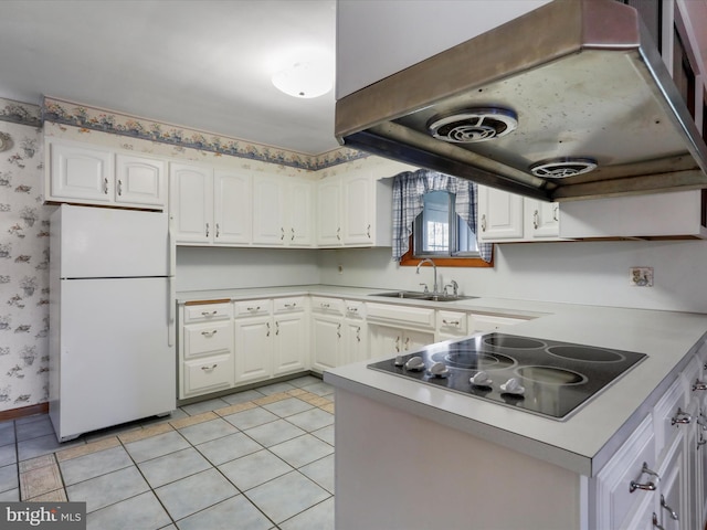 kitchen featuring extractor fan, white cabinets, white fridge, and black electric cooktop