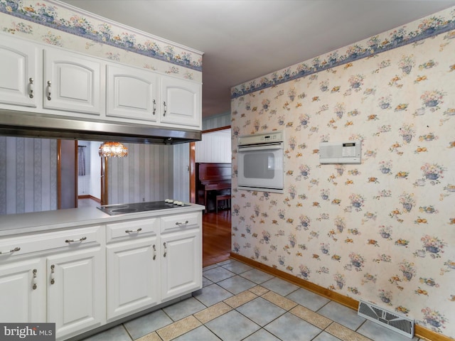 kitchen featuring white cabinetry, oven, light tile patterned floors, and stainless steel electric stovetop