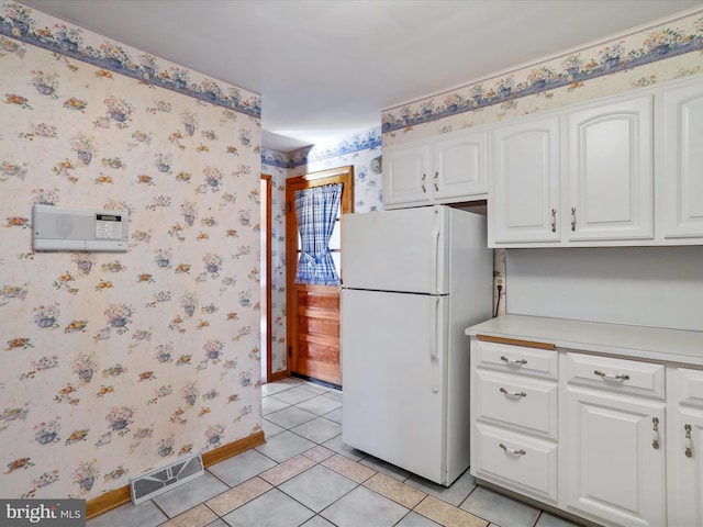 kitchen featuring white cabinetry, light tile patterned flooring, and white refrigerator