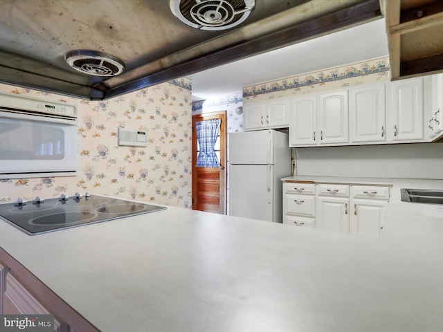 kitchen with white cabinetry and white appliances