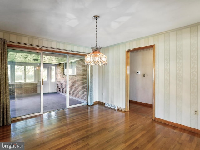 unfurnished dining area with crown molding and dark hardwood / wood-style floors