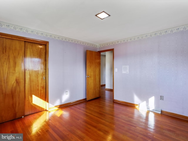 unfurnished bedroom featuring wood-type flooring and a closet