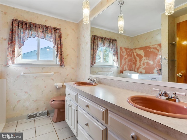 bathroom featuring a wealth of natural light, vanity, toilet, and tile patterned floors