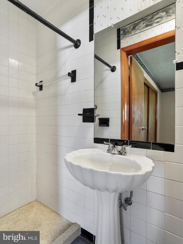 bathroom featuring tile walls and tiled shower