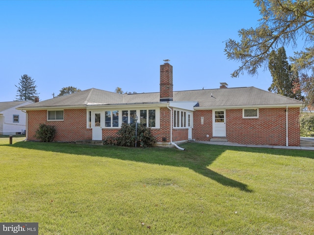 rear view of house featuring a lawn