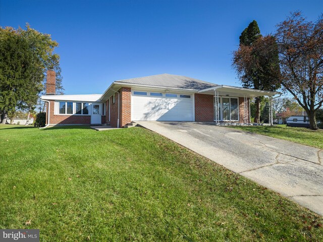 ranch-style home featuring a garage and a front lawn