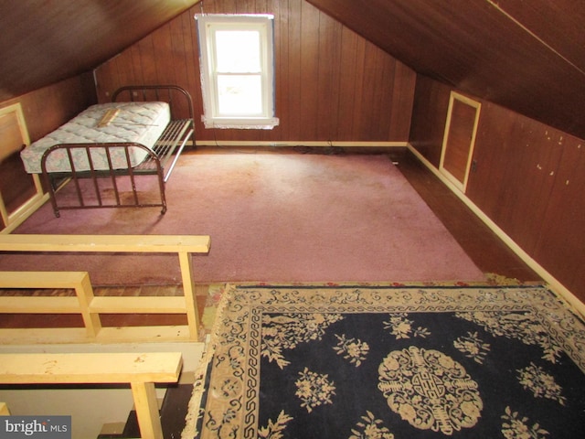 bedroom featuring wooden walls, carpet, wood ceiling, and vaulted ceiling