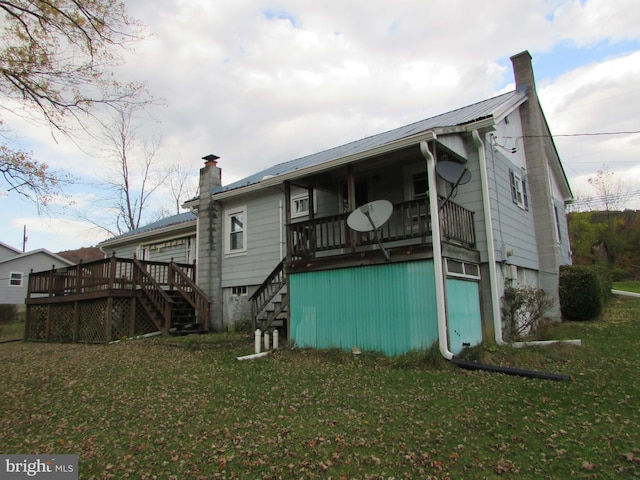 rear view of house featuring a lawn and a wooden deck