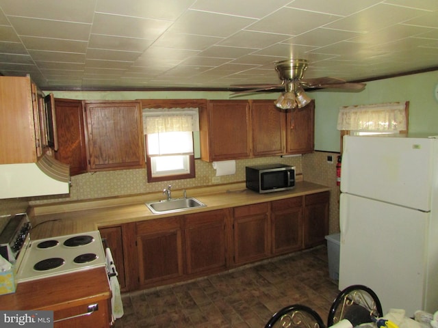 kitchen with dark hardwood / wood-style floors, ceiling fan, white appliances, and sink