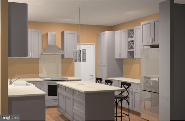 kitchen featuring gray cabinets, wall chimney exhaust hood, a breakfast bar area, and a kitchen island