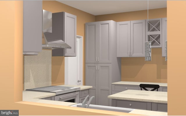 kitchen featuring sink, wall chimney range hood, gray cabinetry, and backsplash