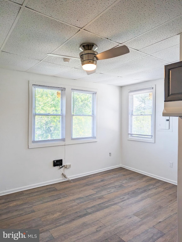 5200 Ballman, Brooklyn, MD 21225 - empty room featuring a wealth of natural light, ceiling fan, dark wood-style floors, and baseboards