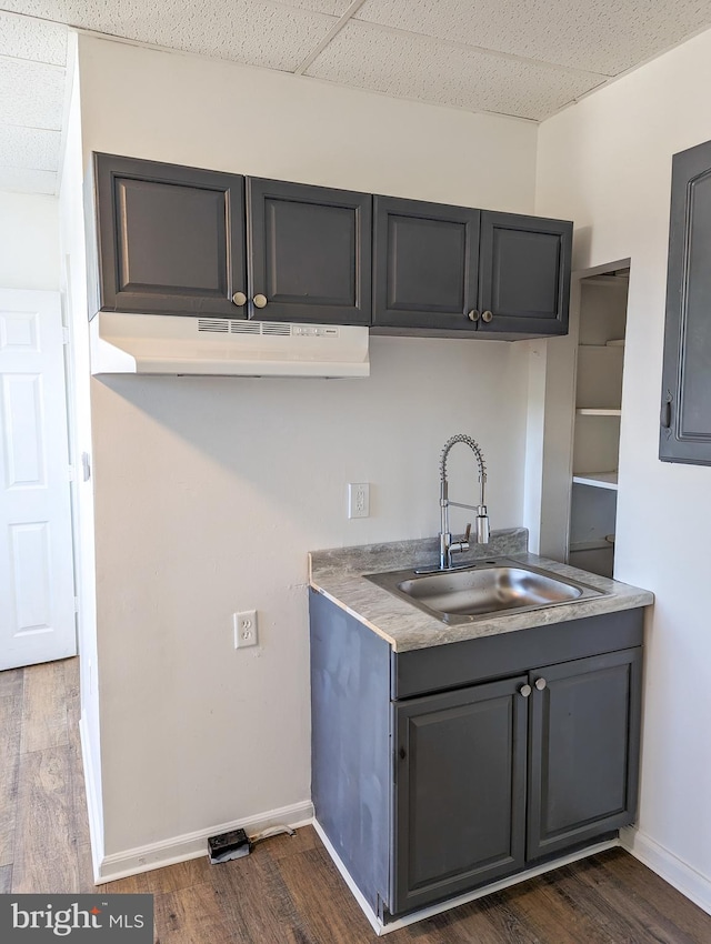 5200 Ballman, Brooklyn, MD 21225 - kitchen with baseboards, under cabinet range hood, dark wood-style floors, and a sink