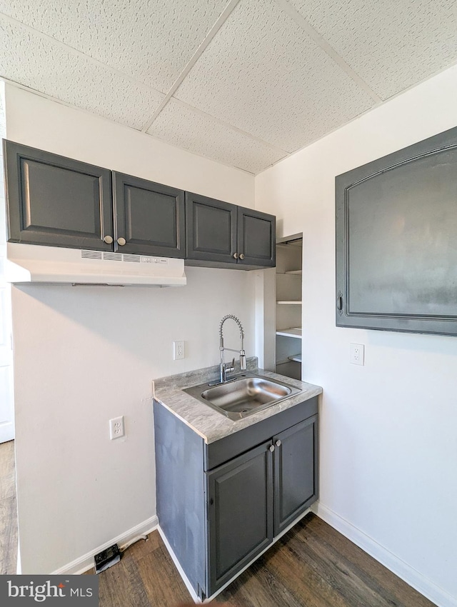 5200 Ballman, Brooklyn, MD 21225 - kitchen featuring baseboards, under cabinet range hood, dark wood-style floors, and a sink