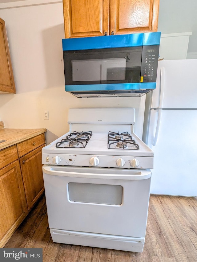 5200 Ballman, Brooklyn, MD 21225 - kitchen with light countertops, brown cabinets, wood finished floors, and white appliances