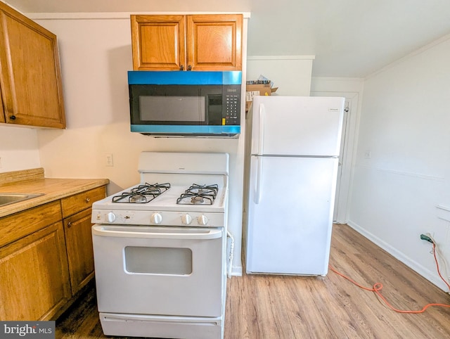 5200 Ballman, Brooklyn, MD 21225 - kitchen with white appliances, light wood finished floors, and brown cabinetry
